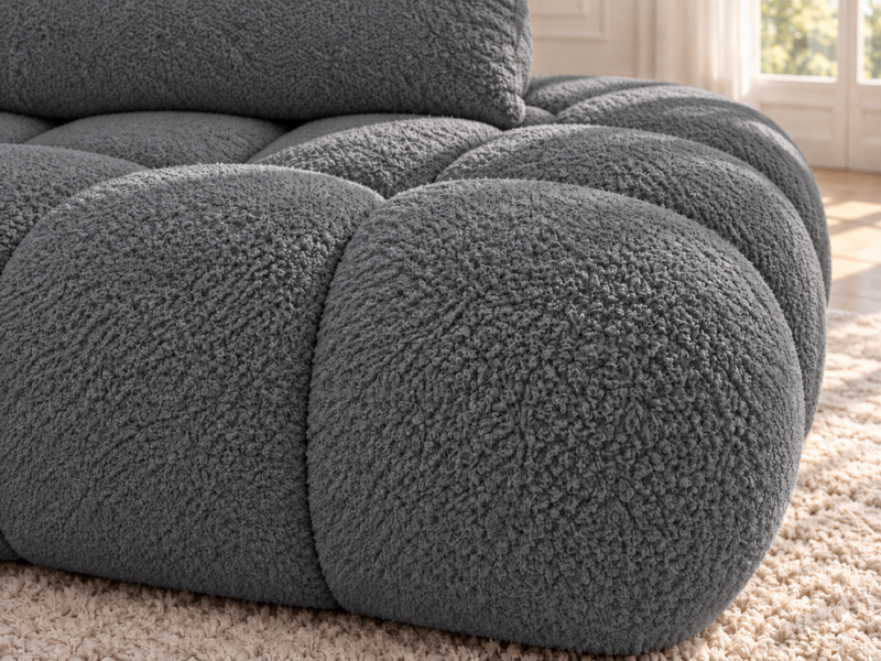 Grafitowa sofa boucle w naturalnym świetle_LEWY Narożnik Soffy lewostronny z funkcją spania i pojemnikiem ciemnoszary boucle