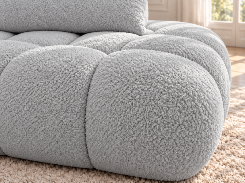 Jasnoszara sofa boucle w ciepłym świetle_LEWY Narożnik Soffy lewostronny z funkcją spania i pojemnikiem szary boucle