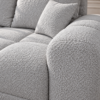 Jasnoszara sofa boucle w zbliżeniu Narożnik z funkcją spania i pojemnikiem Aurio lewy szary boucle