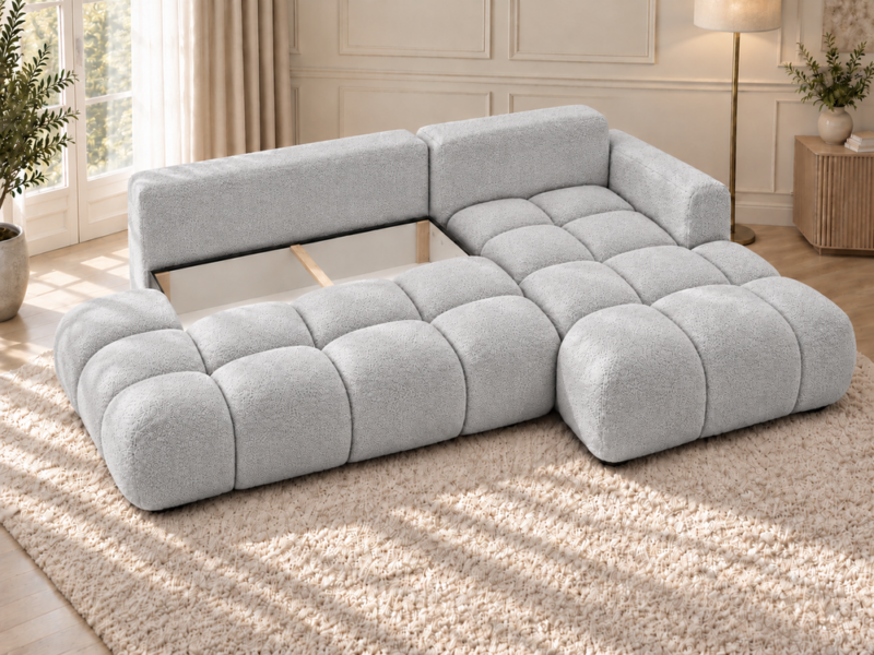 Jasnoszara sofa narożna w słonecznym salonie Narożnik Soffy prawostronny z funkcją spania i pojemnikiem szary boucle