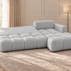 Jasnoszara sofa w ciepłym wnętrzu Narożnik Soffy prawostronny z funkcją spania i pojemnikiem szary boucle