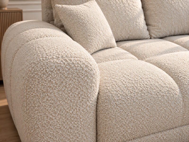 Kremowa sofa bouclé, detal ramienia_PRAWY Narożnik z funkcją spania i pojemnikiem Aurio prawy kremowy boucle
