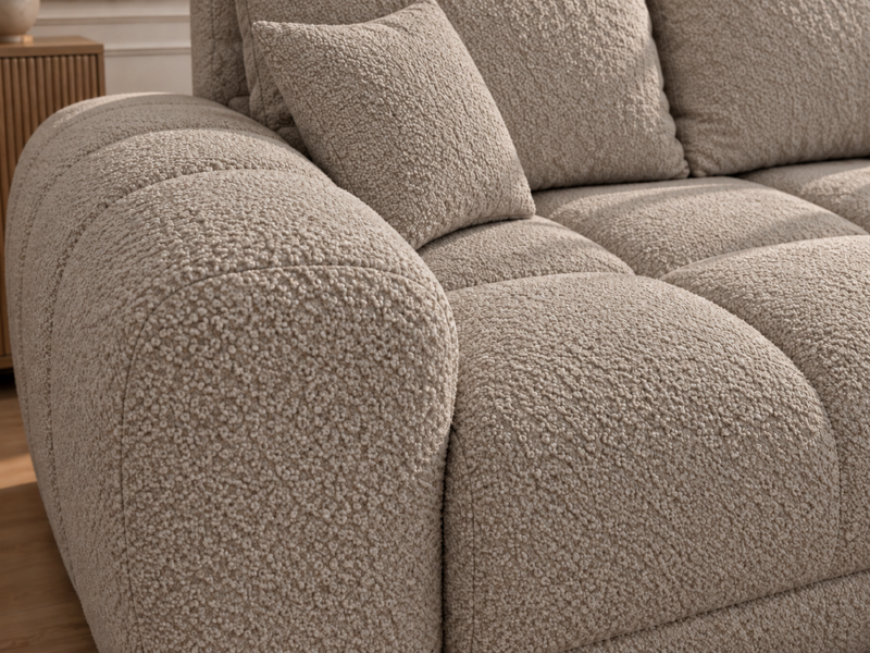 Sofa boucle w ciepłym odcieniu taupe_PRAWY Narożnik z funkcją spania i pojemnikiem Aurio prawy beżowy boucle
