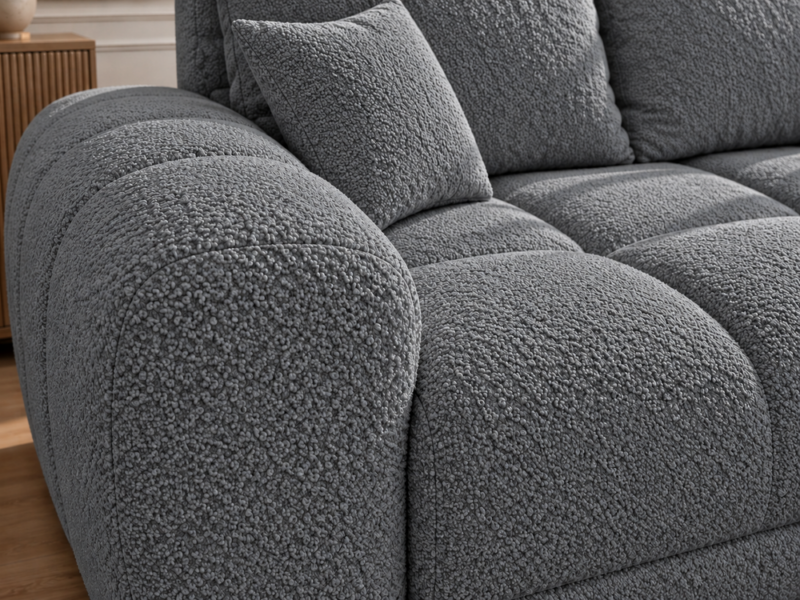 Szara sofa boucle w zbliżeniu_PRAWY Narożnik z funkcją spania i pojemnikiem Aurio prawy ciemnoszary boucle